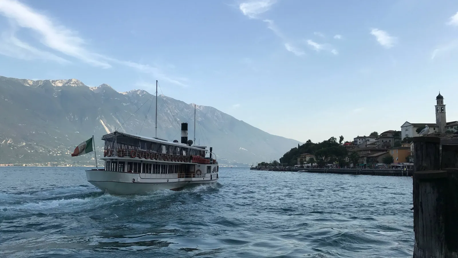 Historischer Raddampfer auf dem Gardasee vor Bergkulisse und Uferpromenade