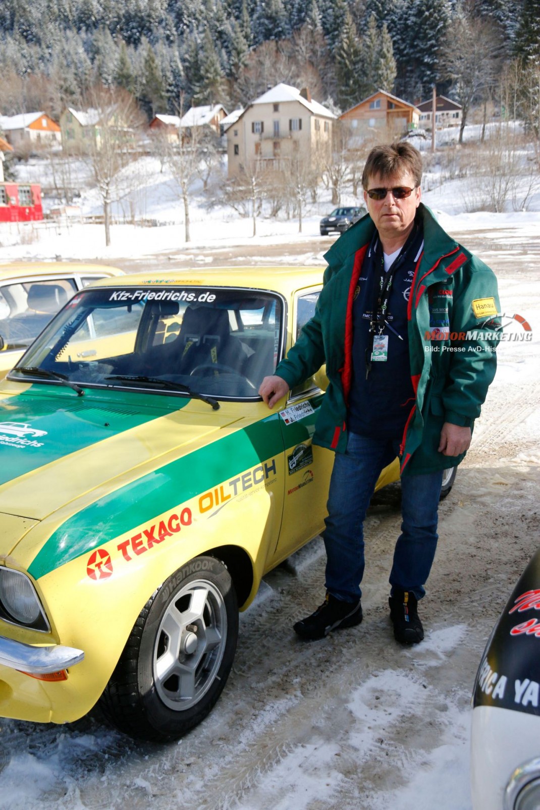 Teilnehmer mit Oldtimer-Sportwagen in Gelb-Grün-Lackierung bei der AvD-Histo-Monte Rally in Berglandschaft mit Schnee