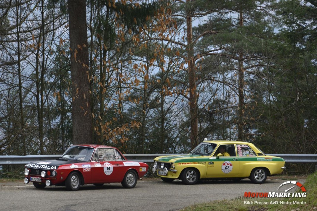 Zwei Oldtimer-Sportwagen nebeneinander auf einer Straße vor Waldkulisse während der AvD-Histo-Monte-Rallye