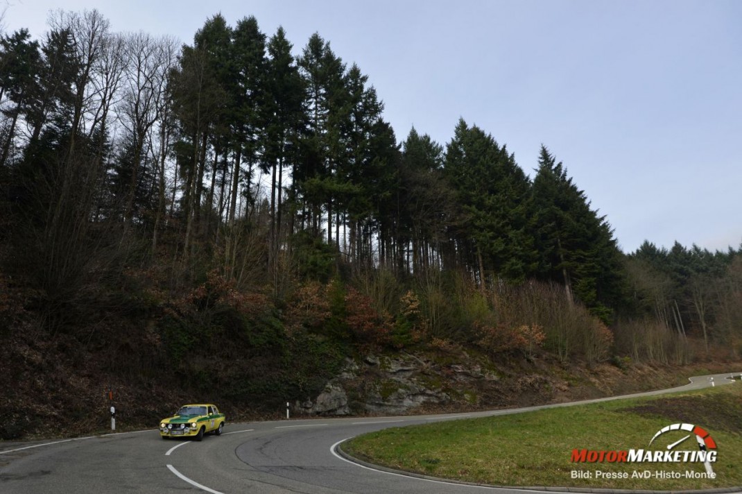 Gelber Oldtimer-Sportwagen in Kurve auf Bergstraße mit Wald bei AvD-Histo-Monte