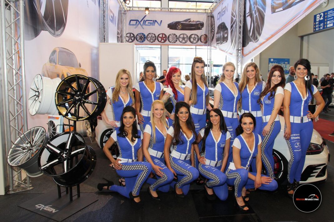 Gruppe von Frauen in blauen Westen posiert vor Felgen und Autoreifen am Messestand der TuningWorld Bodensee