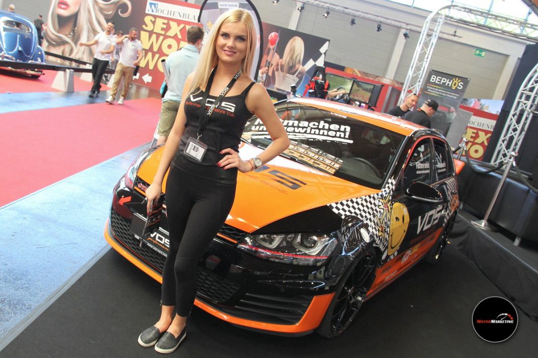 Frau neben orangefarbenem Tuning-Sportwagen auf der Messe-Ausstellungsfläche der TuningWorld Bodensee 2016