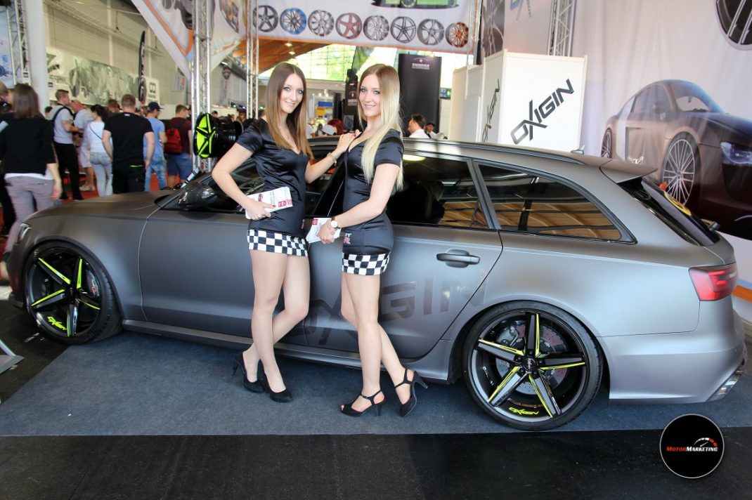 Zwei Moderatorinnen präsentieren einen silbernen Tuning-Kombi mit neongelben Felgen auf der TuningWorld Bodensee 2016