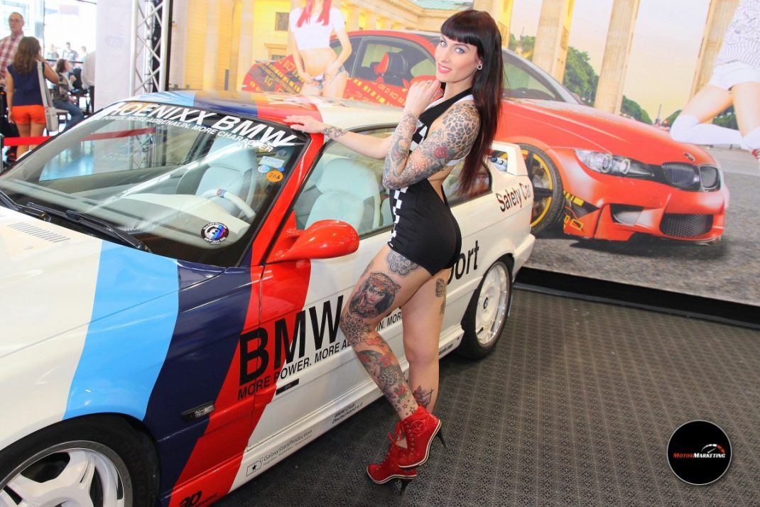Frau posiert an einem rot-weiß-blau lackierten BMW Cabrio auf der TuningWorld Bodensee