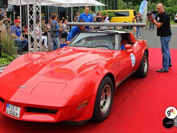 Roter Corvette-Sportwagen auf rotem Teppich bei der Ruhr Klassik 2016, Besucher und Helfer im Hintergrund