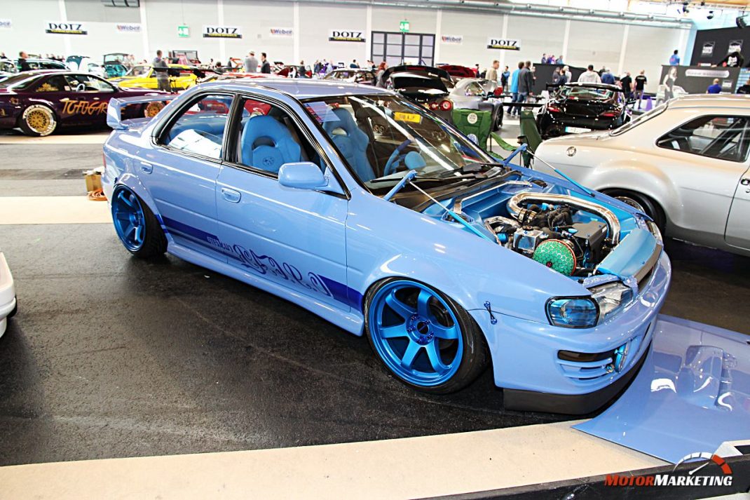 Hellblauer Youngtimer mit geöffneter Motorhaube und blauen Felgen auf der European Tuning Showdown 2017, umgeben von weiteren Fahrzeugen und Besuchern