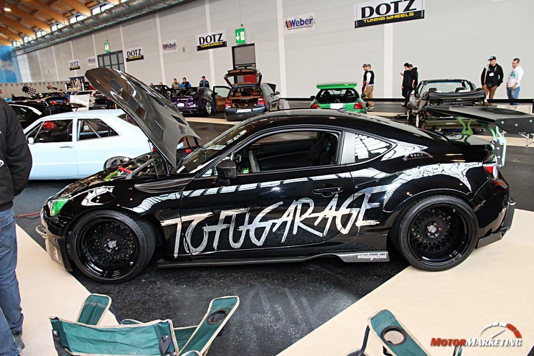 Getunter schwarzer Sportwagen mit offener Motorhaube auf der Ausstellungsfläche des European Tuning Showdown 2017 in einer Halle