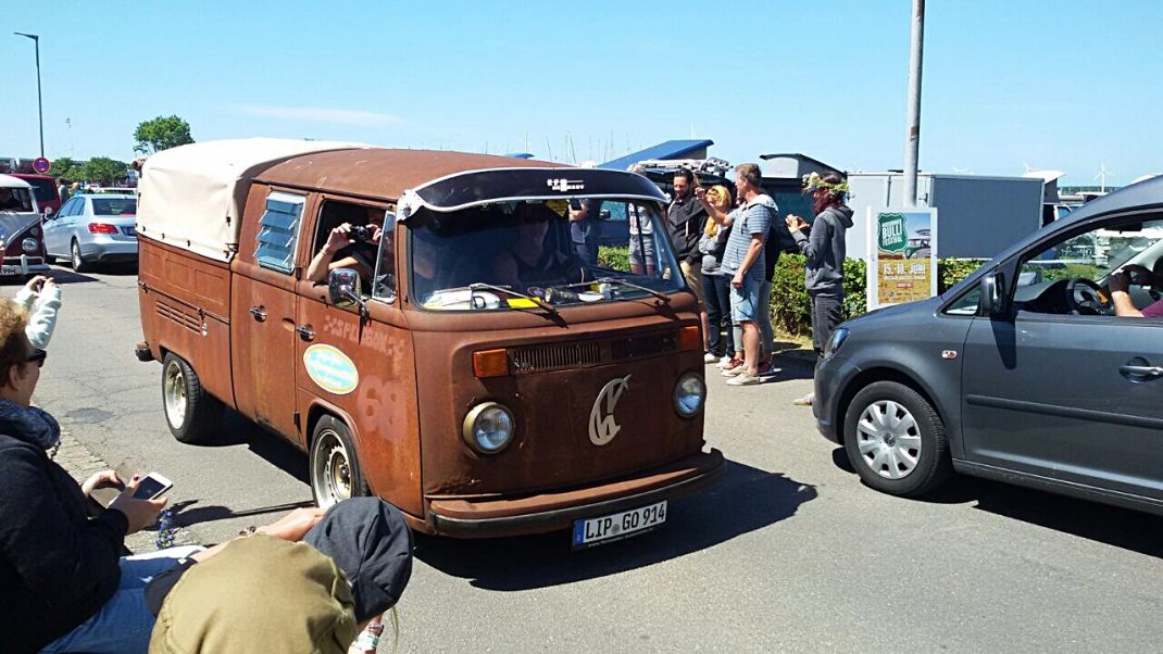 Rostiger VW-Bulli mit Plane auf dem Midsummer Bulli Festival, umgeben von Besuchern und anderen Fahrzeugen