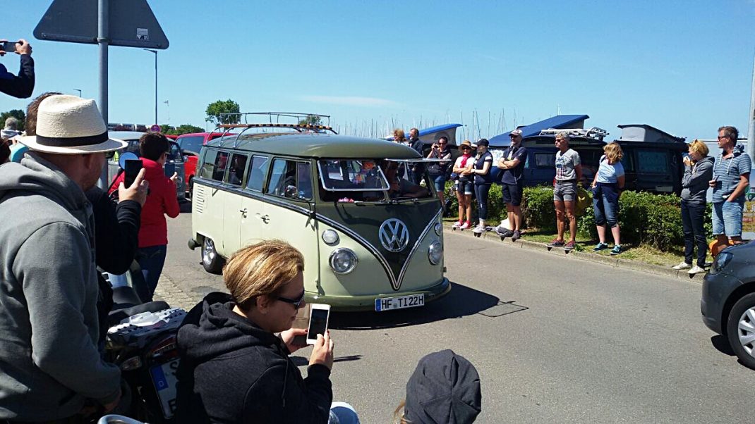VW Bulli in Creme-Grün und Schwarz beim Midsummer Bulli Festival auf Fehmarn, Besucher und Fotografen rundherum