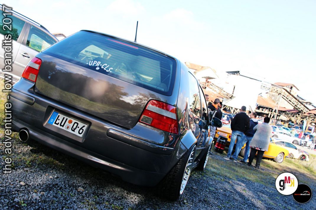 Schwarzer Youngtimer-Kombi von hinten auf Treffen mit Besuchern und anderen Fahrzeugen im Hintergrund