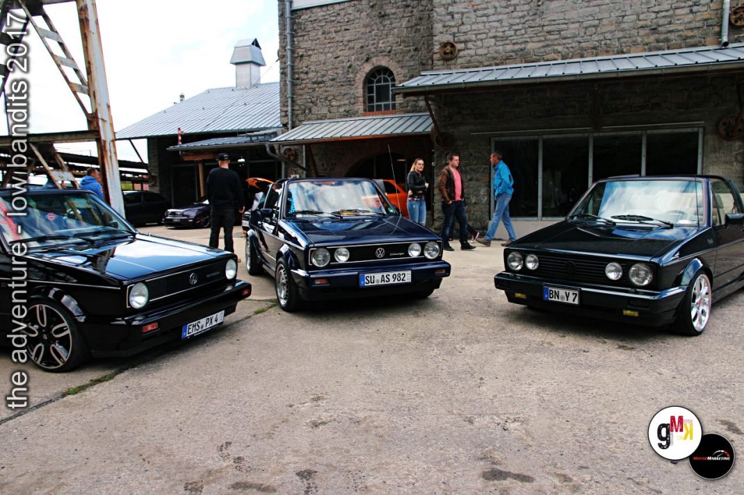 Drei Oldtimer-Limousinen nebeneinander auf dem Innenhof eines Steinbruchs, Teilnehmer stehen daneben und betrachten die Fahrzeuge
