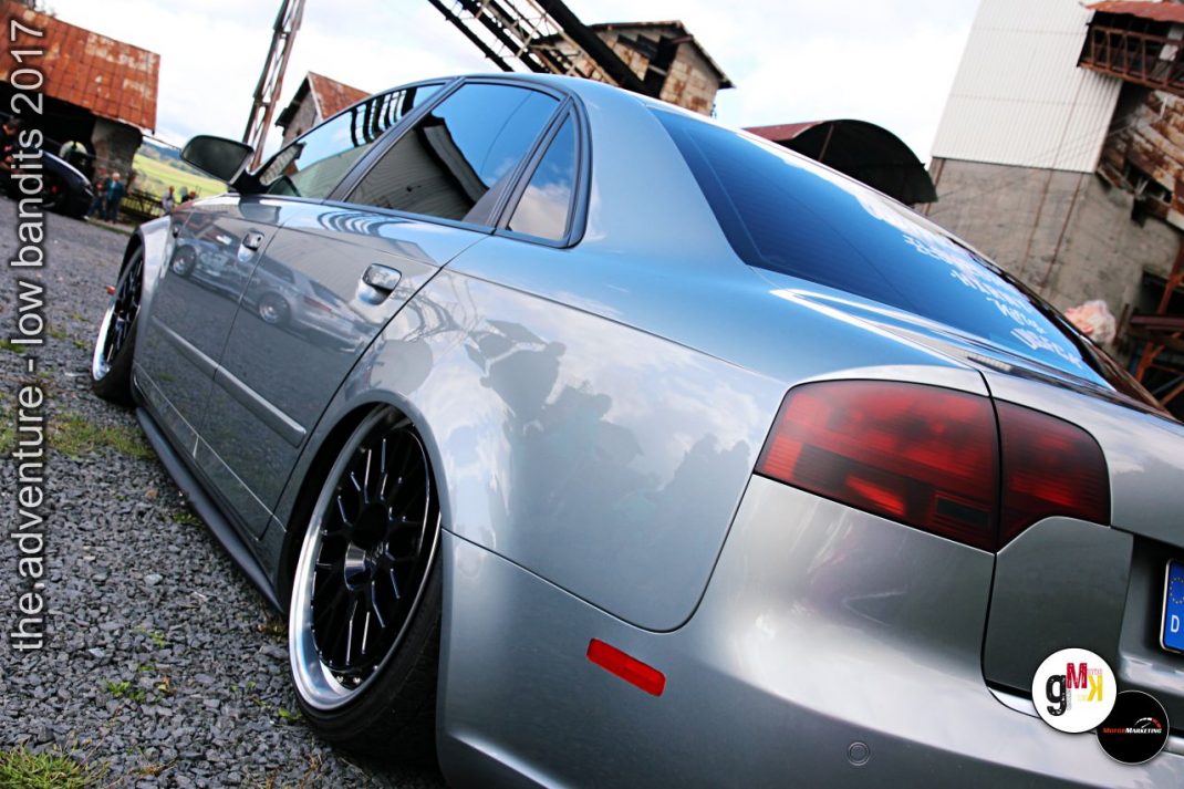 Silberfarbene Youngtimer-Limousine mit Tieferlegung und Sportfelgen auf Gelände einer Tuning-Veranstaltung