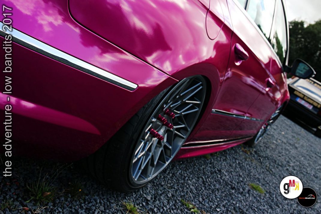 Magentafarbener Youngtimer mit glänzender Lacoberfläche und schwarzer Leichtmetallfelge im Detail bei Tuning-Treffen