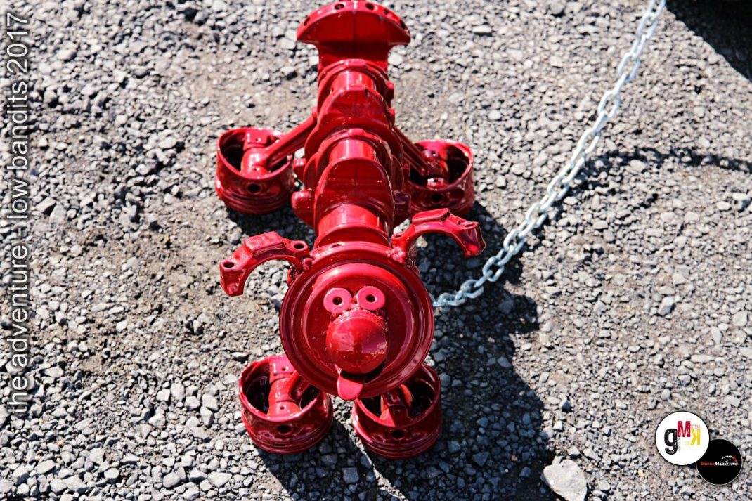 Rotes Oldtimer-Lokomotivenmodell auf Kieselfläche bei Tuning-Event im Steinbruch