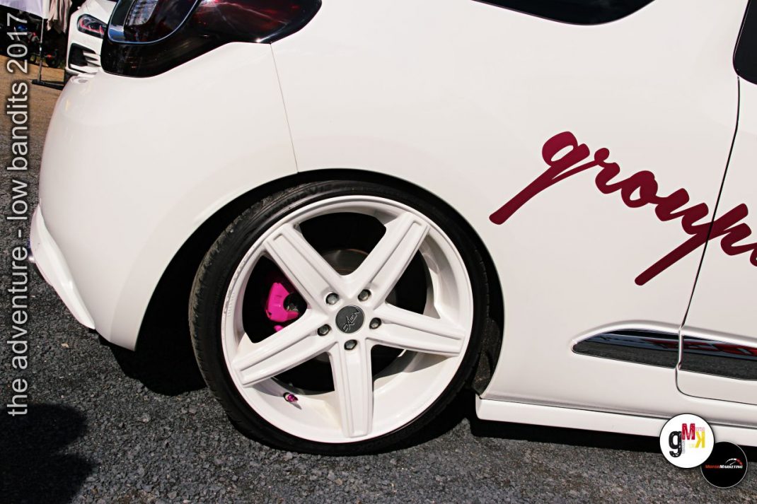 Weiße Limousine mit tiefergelegtem Fahrwerk, weißen Alufelgen und pinkfarbenen Bremsanlagen beim Low Bandits 2017 Tuning-Event