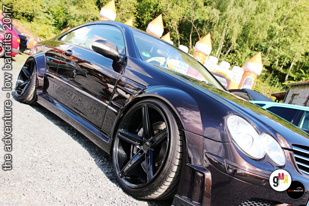 Schwarzer Youngtimer-Sportwagen mit Tiefbettfelgen auf Parkplatz bei Low Bandits 2017 Tuning-Event im Steinbruch