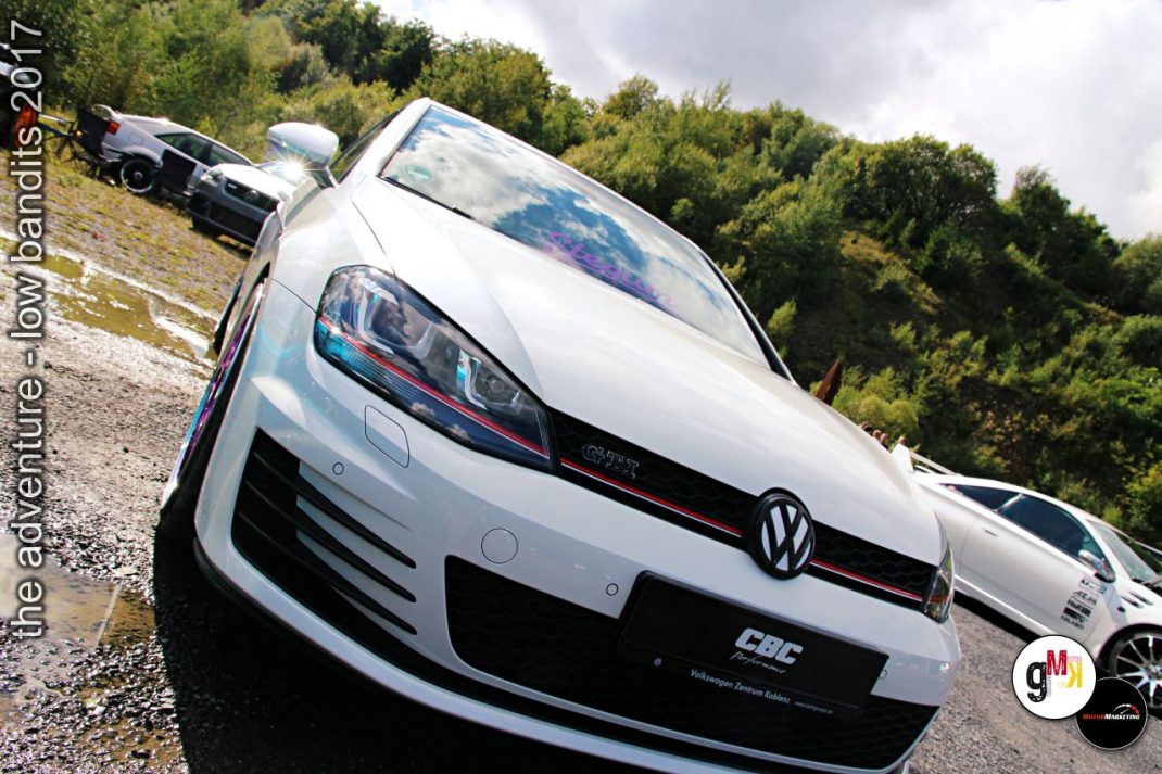 Weißer Volkswagen Golf mit Sportausstattung auf Veranstaltung The adventure low bandits 2017 in Steinbruch, weitere getuntes Auto im Hintergrund