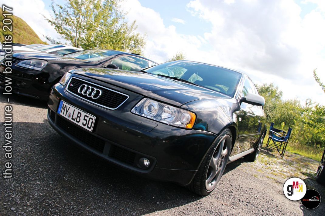 Schwarze Audi-Limousinen parken auf Schotterstraße bei Youngtimer-Tour "The adventure – low bandits 2017