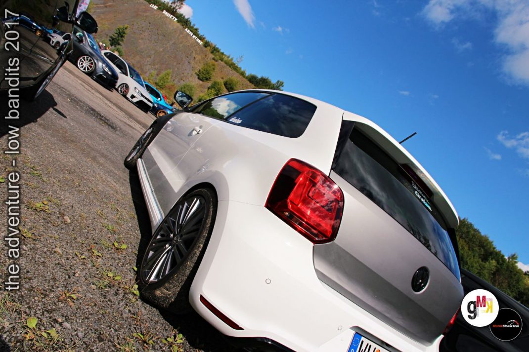 Weiße Youngtimer-Limousine mit roten Rückleuchten beim Tuning-Treffen im Steinbruch, weitere Fahrzeuge im Hintergrund