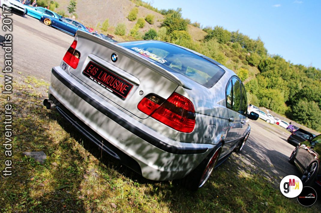 BMW Limousine mit Limousinen-Schriftzug von hinten bei Oldtimer-Treffen am bewaldeten Hang mit weiteren Fahrzeugen