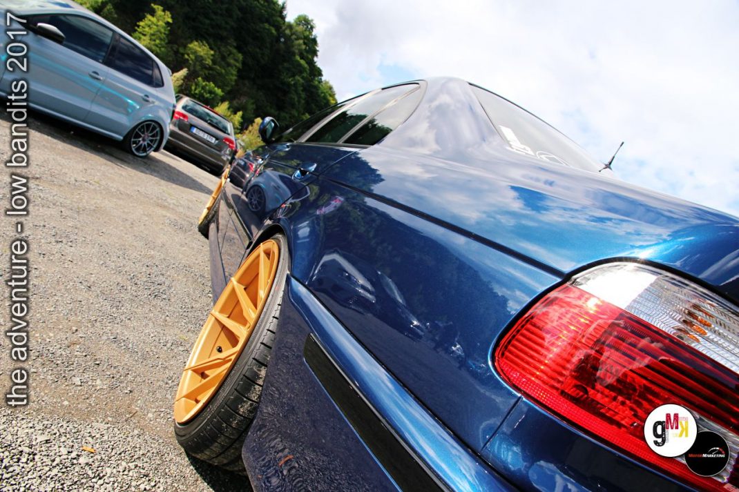 Mehrere Tuning-Fahrzeuge mit goldenen Felgen und tiefergelegten Fahrwerken beim Low-Bandits-Treffen im Steinbruch
