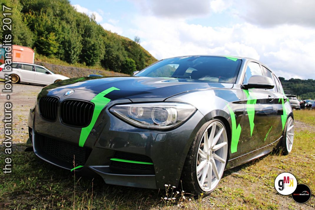 Schwarze BMW-Limousine mit neongrünen Tuning-Akzenten auf Parkplatz beim Low-Bandits-Tuning-Event 2017