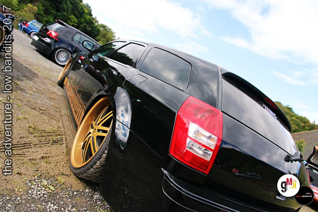 Schwarzer Youngtimer-SUV mit goldenen Leichtmetallrädern neben tiefer gelegtem Oldtimer-Cabrio beim Treffen „The Adventure – Low Bandits 2017