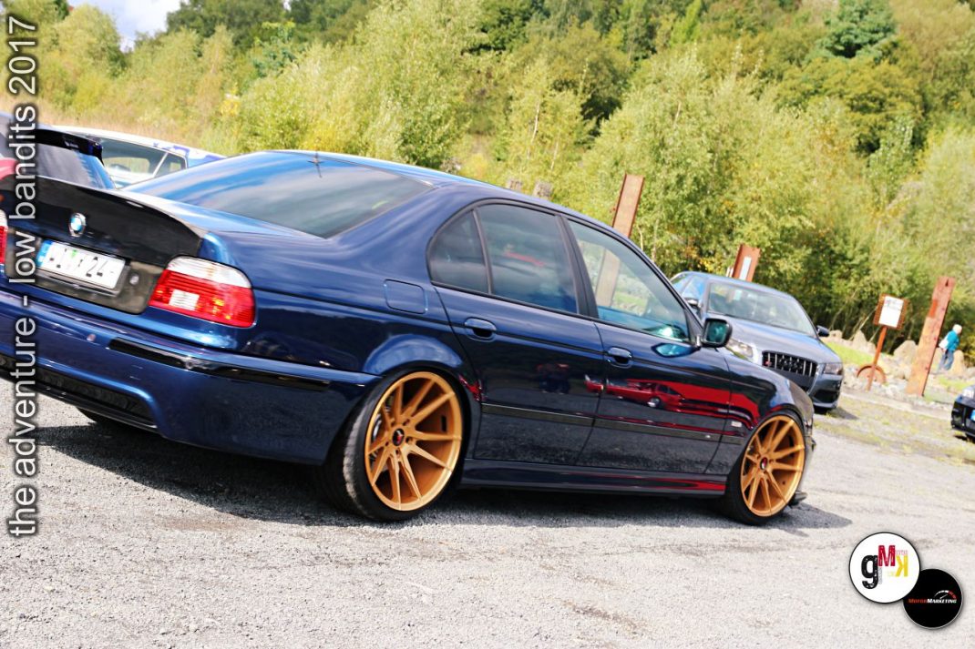 Blaue Youngtimer-Limousine mit goldenen Felgen auf Parkplatz beim Tuning-Event im Steinbruch