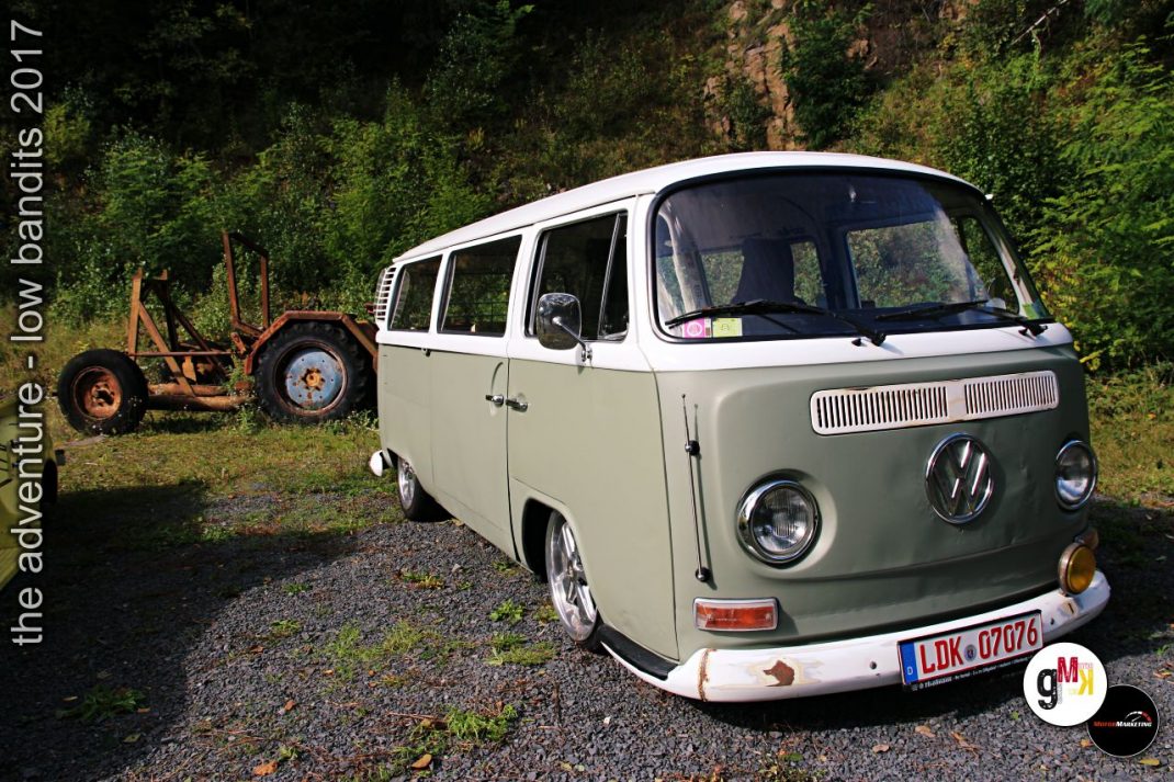 Zweifarbiger VW-Bulli vor bewaldeter Kulisse und altem Traktor bei der Low-Bandits-Rallye 2017