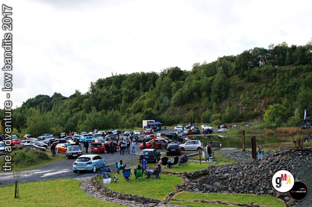 Teilnehmer und Oldtimer-Fahrzeuge versammeln sich auf einem Parkplatz im Steinbruch während der Low Bandits 2017 Veranstaltung
