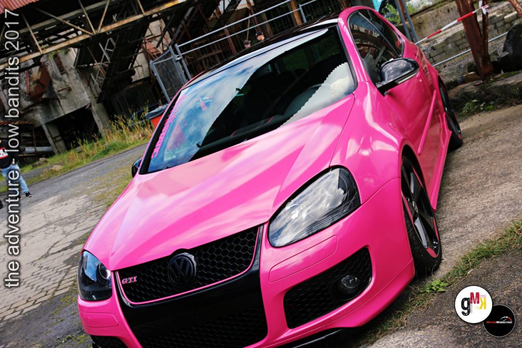Pink lackierter VW Golf GTI mit geöffneter Fahrertür in Steinbruch-Kulisse bei Tuning-Event