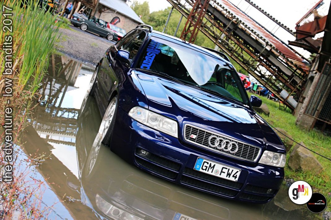 Dunkelblauer Audi Youngtimer durchfährt Pfütze auf rustikalem Gelände bei Low Bandits Tuning-Event 2017