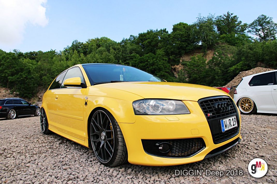 Gelber Audi-Kompaktwagen auf Kiesplatz mit weiteren Oldtimern und Youngtimern beim DIGGIN' Deep Event in der Eifel