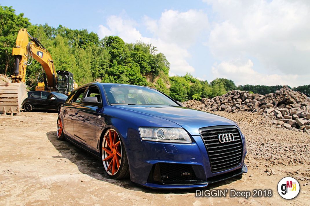 Blauer Audi-Youngtimer mit orangenen Felgen auf Schottergelände mit Bagger und Gesteinshalden bei der DIGGIN' Deep 2018 in der Eifel