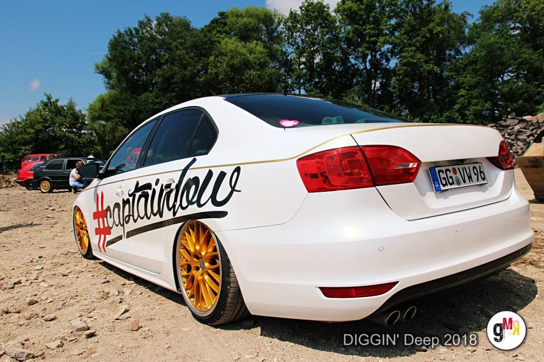 Weiße Youngtimer-Limousine mit goldenen Felgen und individueller Beschriftung auf Veranstaltungsgelände in der Eifel