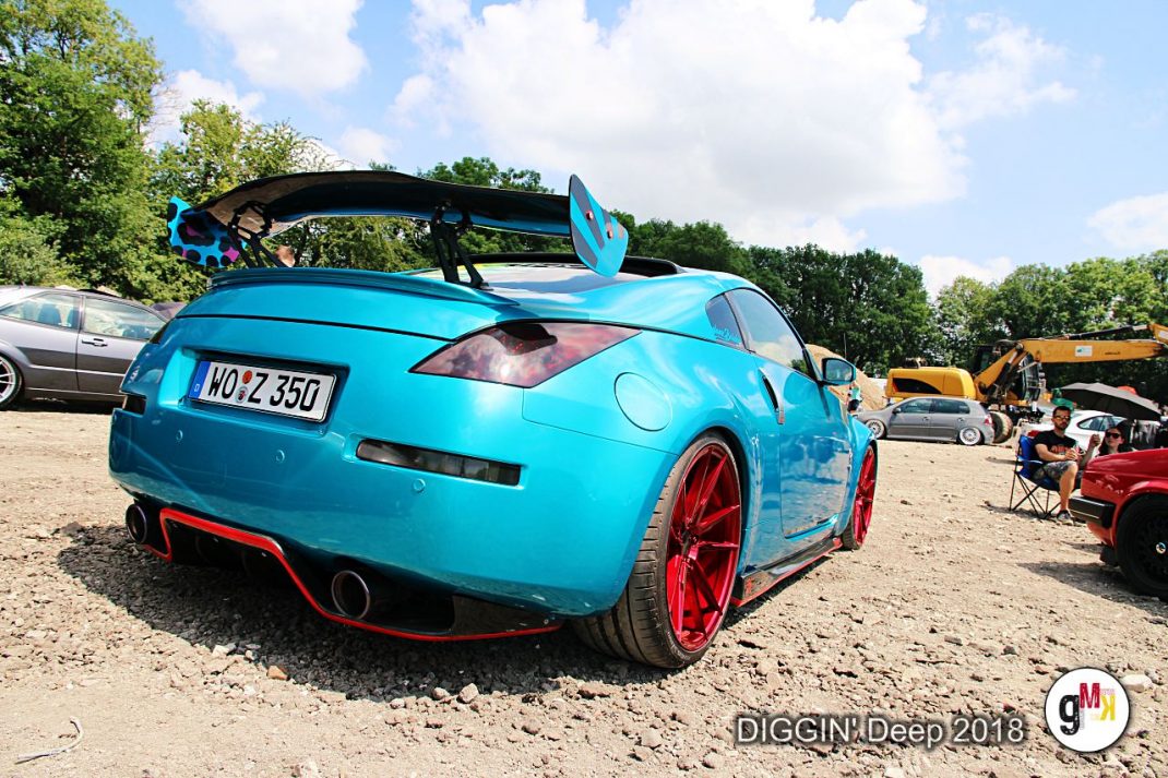 Türkis lackierter Youngtimer-Coupé mit rotem Tieferlegungskit und Surfbrett auf dem Dach beim Auto-Event DIGGIN' Deep in der Eifel