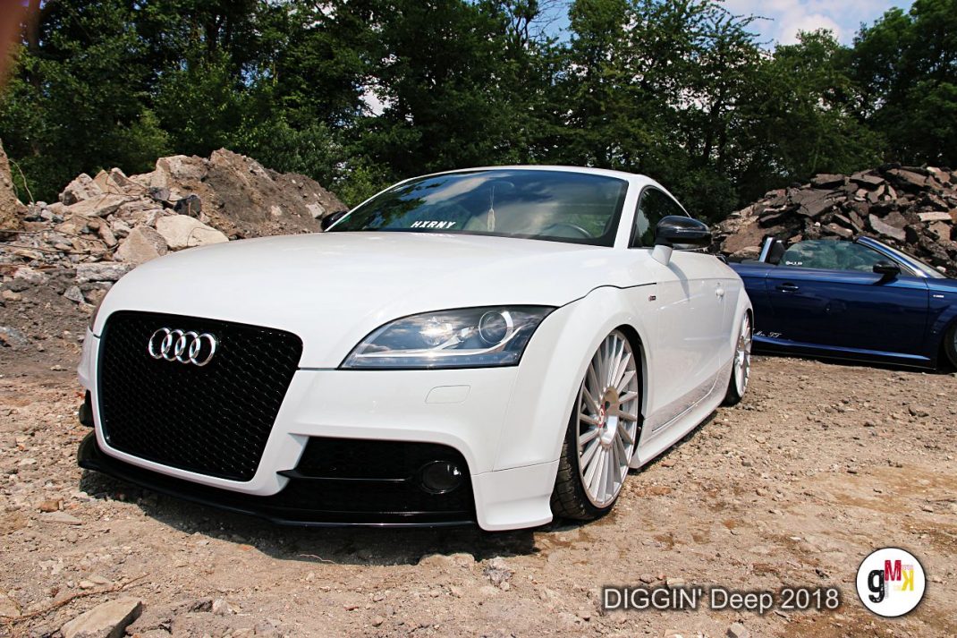 Weißer Audi Coupé mit schwarzem Kühlergrill auf unbefestigtem Gelände während der Youngtimer-Tour DIGGIN' Deep 2018 in der Eifel