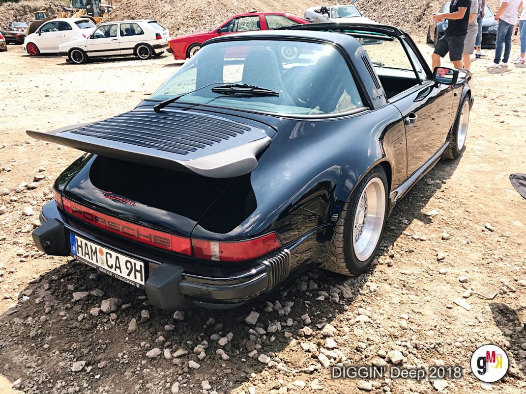 Schwarzer Porsche-Cabrio mit offener Motorhaube und Tonneau-Cover auf der DIGGIN' Deep 2018 in der Eifel, weitere Oldtimer im Hintergrund