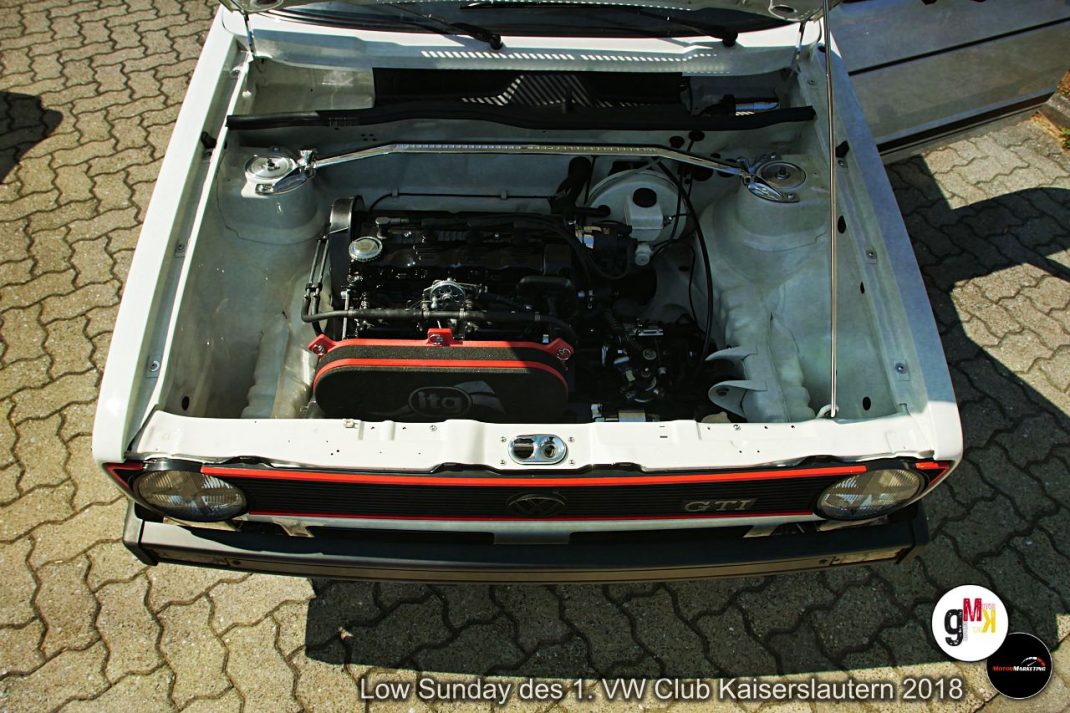 Offener Motorraum eines VW Golf GTI mit rot-schwarzem Motorblock auf Pflastersteinen beim Low Sunday des VW Club Kaiserslautern 2018