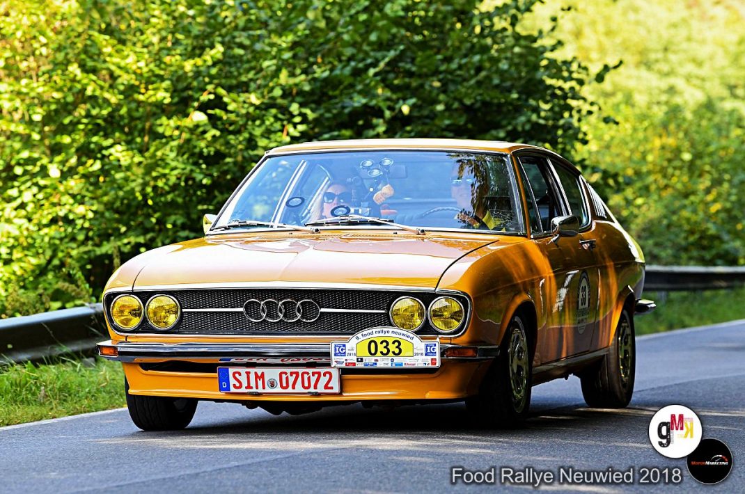 Goldfarbener Audi Oldtimer mit vier Scheinwerfern fährt bei der Food Rallye Neuwied 2018 auf grüner Landschaftsstraße