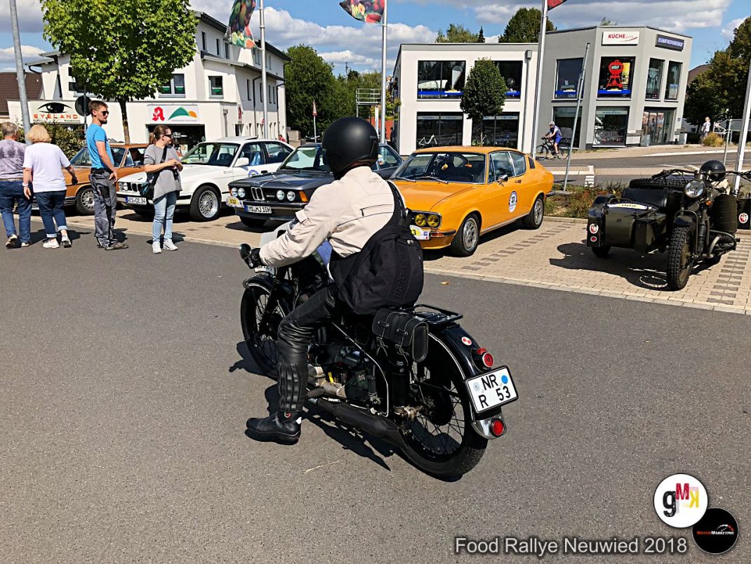 Motorradfahrer auf klassischem Motorrad bei der Food Rallye Neuwied 2018, im Hintergrund Oldtimer-Autos und Besucher