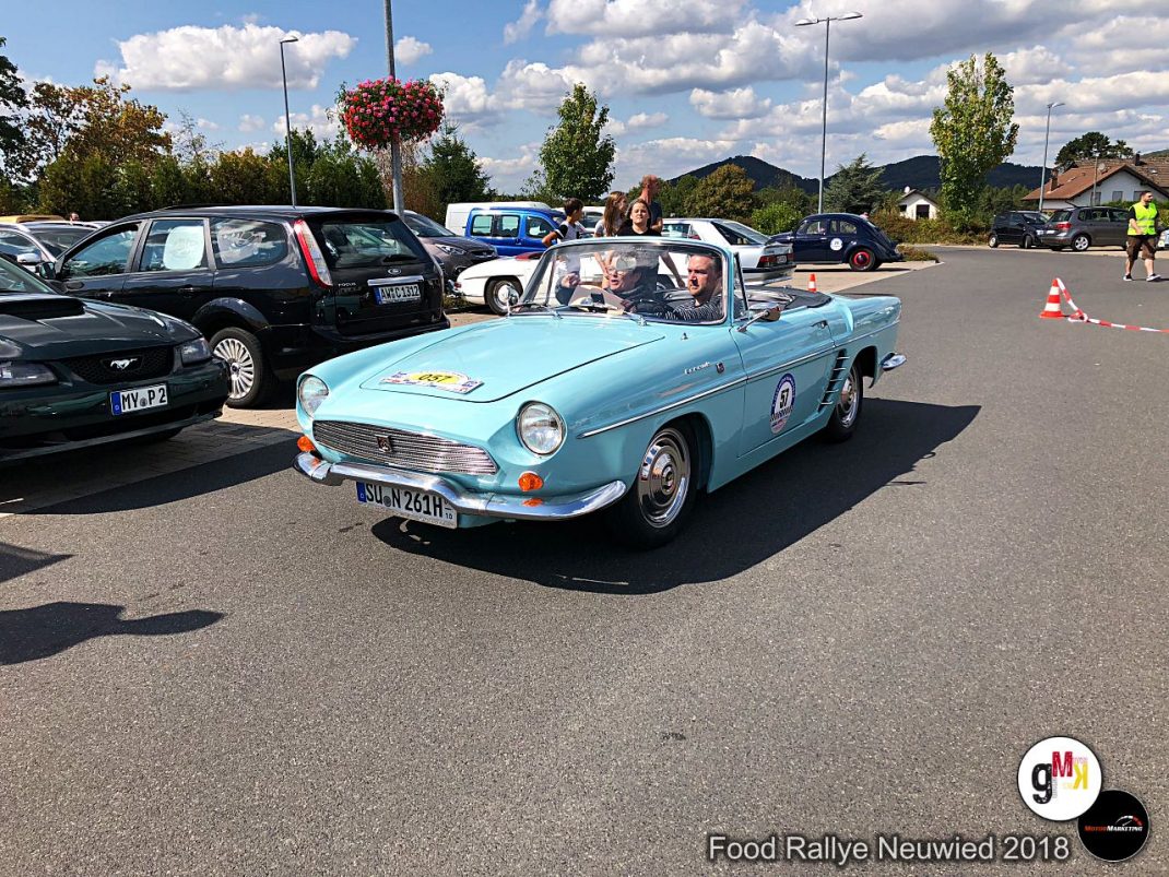 Hellblauer Oldtimer-Cabrio mit Fahrerin und Fahrgast fährt auf Parkplatz während der Food Rallye Neuwied