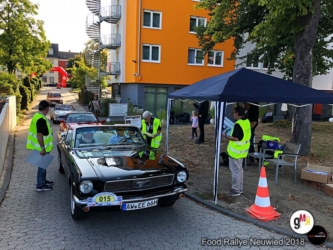 Helfer in Warnwesten kontrollieren einen Oldtimer-Cabrio mit Startnummer an der Zielstelle der Food Rallye Neuwied