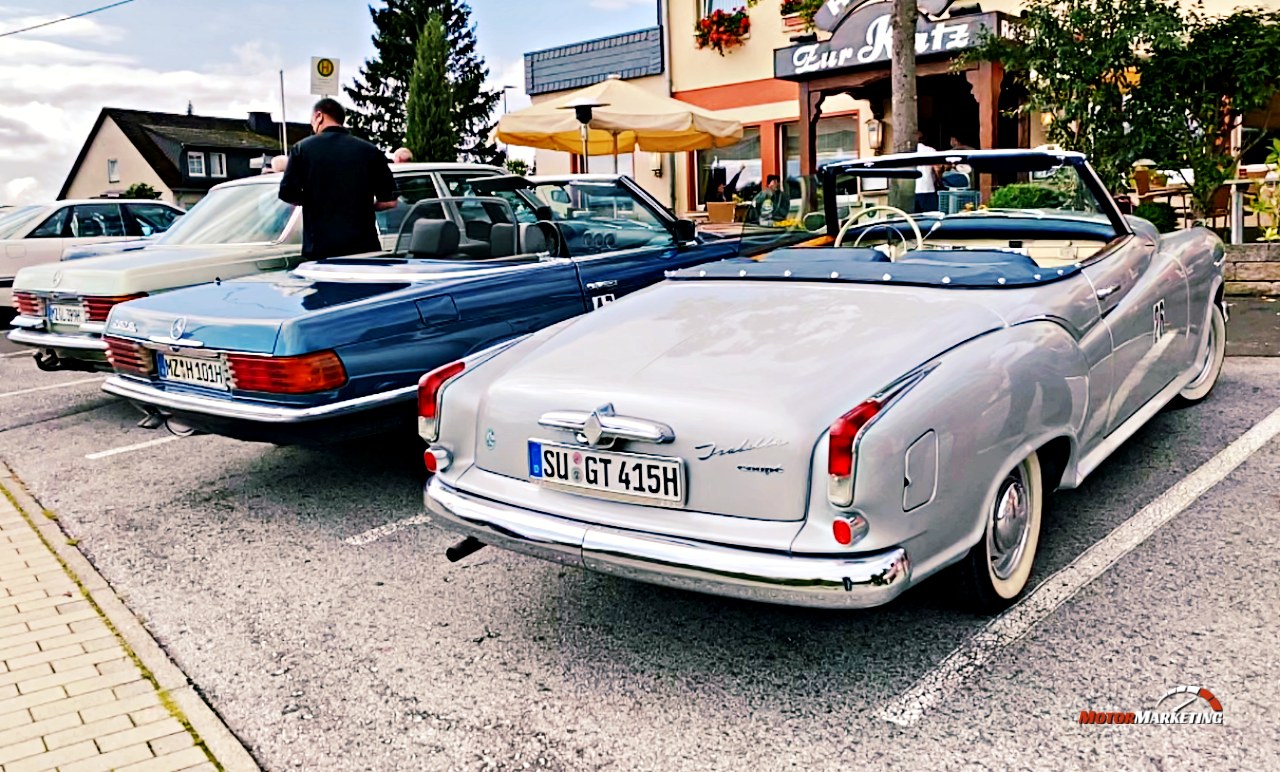 Silbernes Oldtimer-Cabrio und blauer Oldtimer-Mercedes auf Parkplatz bei Klassiker-Veranstaltung