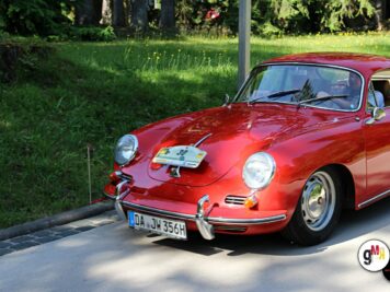 Roter Porsche 356 mit Rallye-Nummer an grüner Hecke während der ADAC Oldtimerfahrt Hessen-Thüringen
