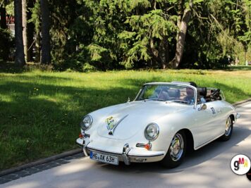 Porsche 356 Cabrio in Weiß bei der ADAC Oldtimerfahrt Hessen-Thüringen 2022, geparkt vor grüner Parklandschaft