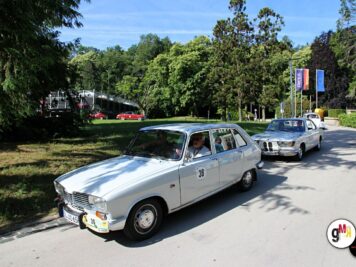 Oldtimer-Limousinen in Kolonne beim Parkplatz-Start einer ADAC-Rallye, Fahrer in den Fahrzeugen, Bäume im Hintergrund
