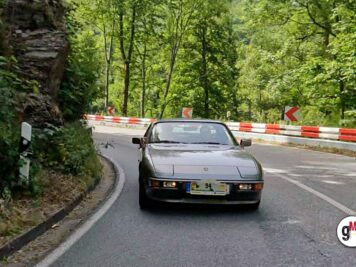 Youngtimer-Sportwagen fährt auf kurviger Waldstraße mit rot-weißen Leitplanken bei der ADAC Oldtimerfahrt Hessen-Thüringen