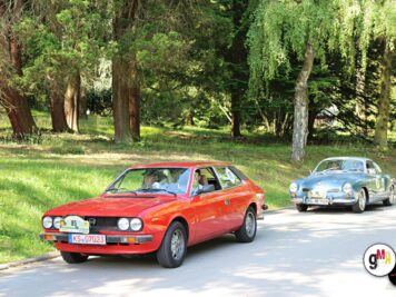 Roter Oldtimer-Sportwagen und silberner Klassiker fahren auf einer Parkstraße unter Bäumen während der ADAC Oldtimerfahrt Hessen-Thüringen