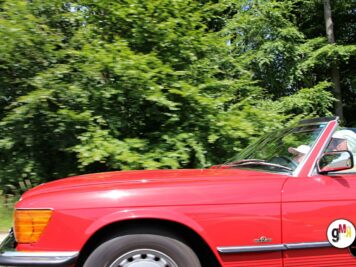 Roter Oldtimer-Cabriolet mit Fahrer in Fahrt durch grüne Waldlandschaft bei der ADAC Oldtimerfahrt Hessen-Thüringen